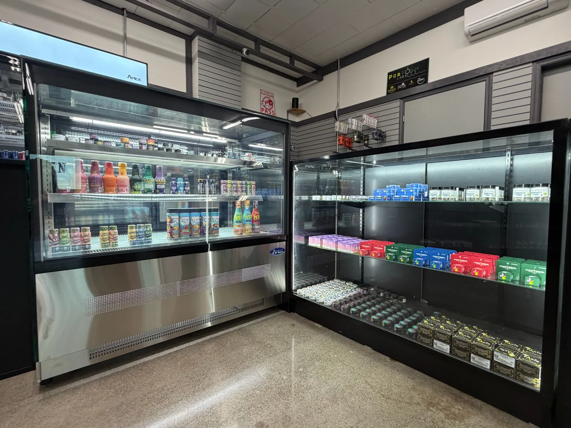 A refrigerated display and a lit glass case of cannabis products at Crystal Leaves