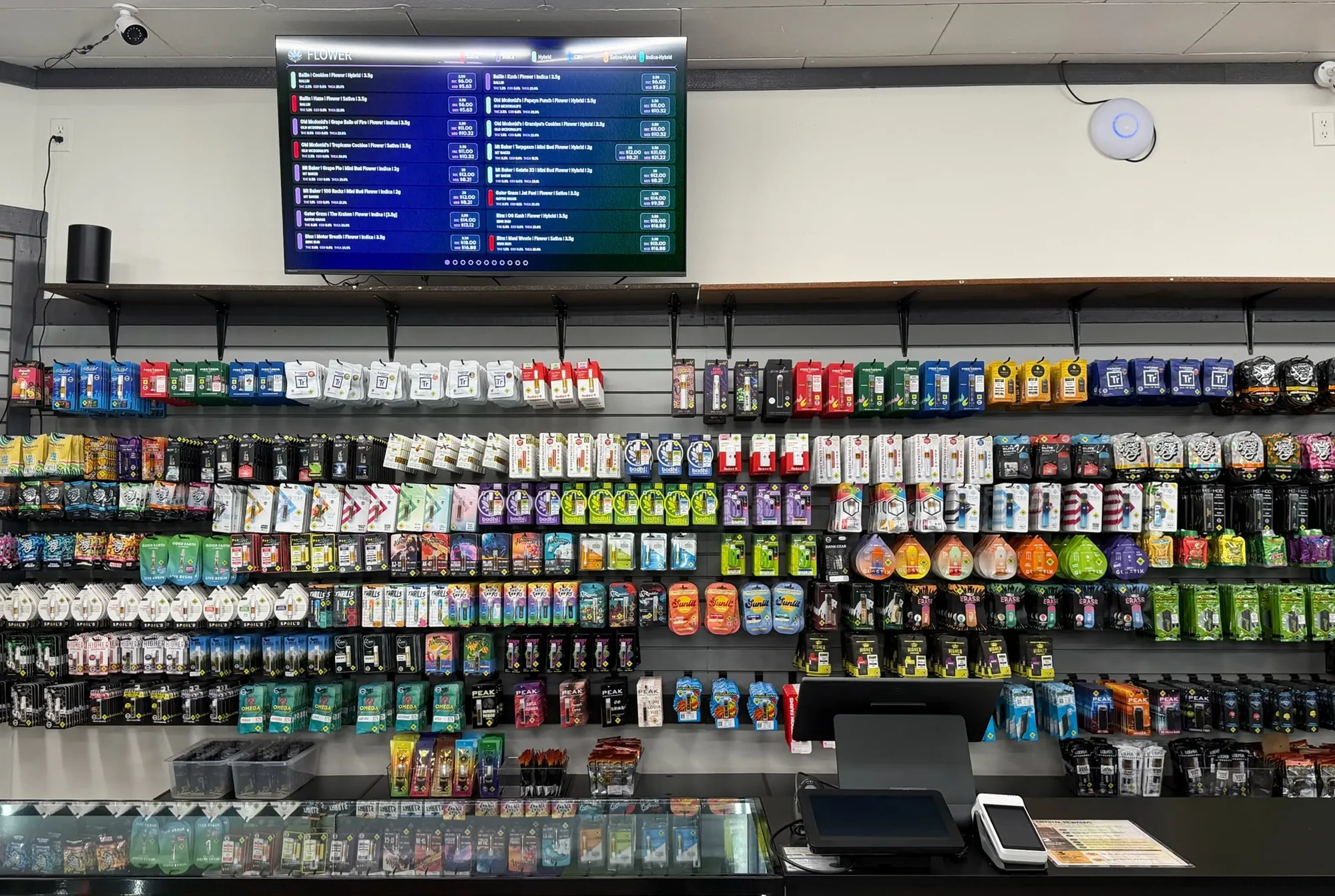 The product wall behind the Crystal Leaves counter under the digital menu screen