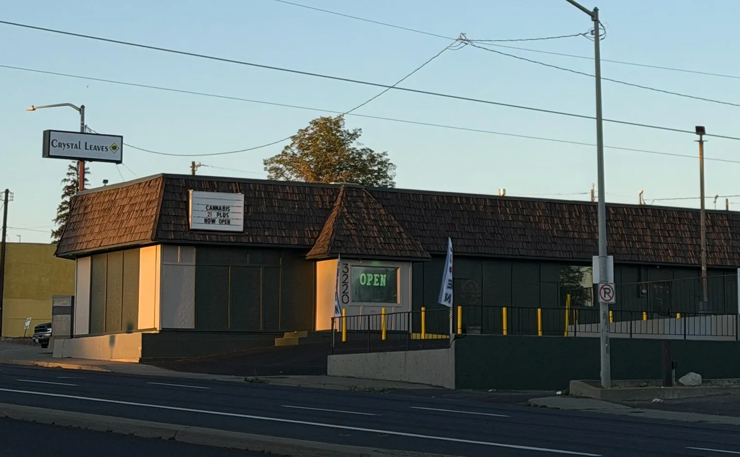 Crystal Leaves storefront on N Division St in Spokane at sunset, with the open sign lit