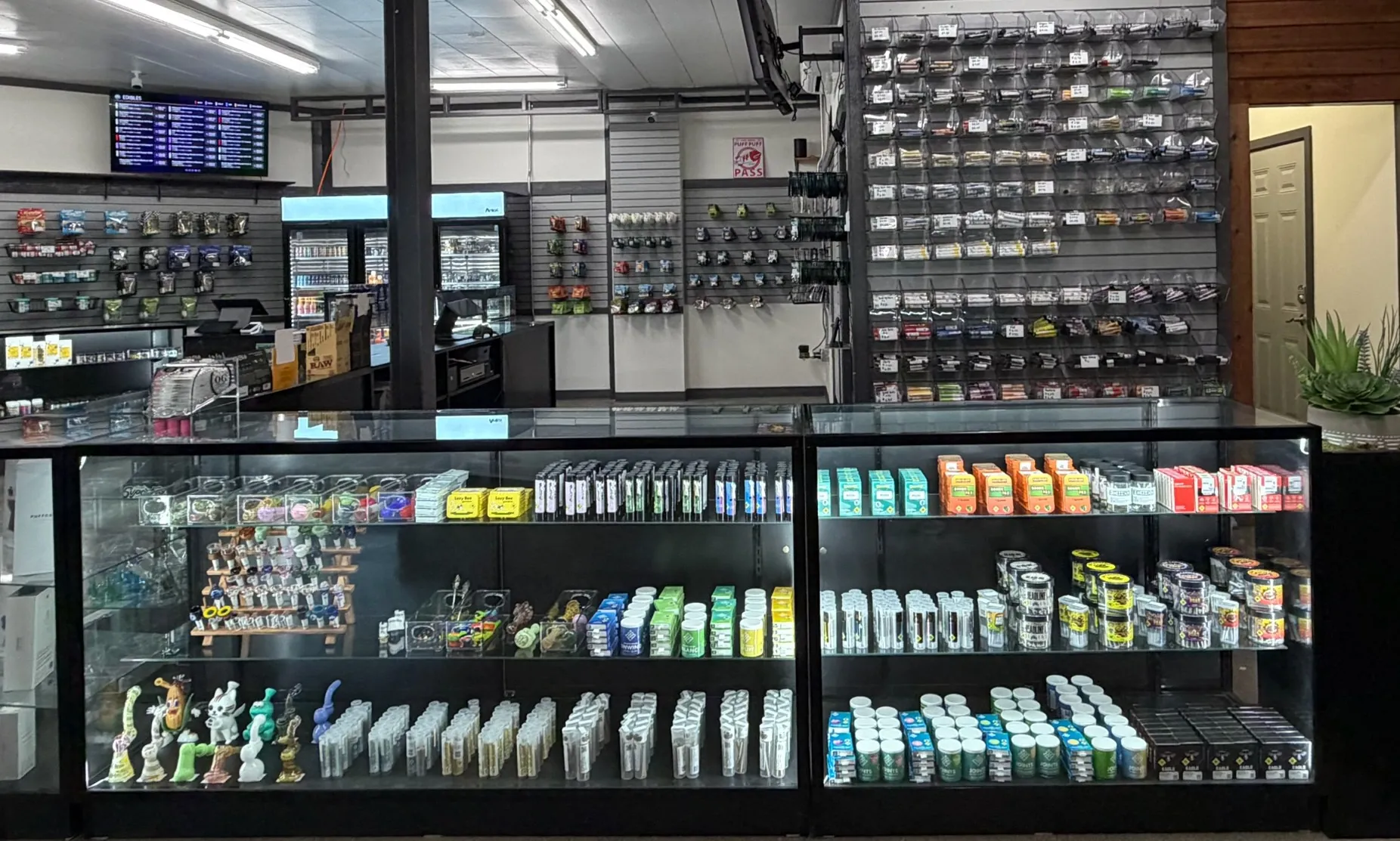 Glass display cases with pipes and packaged products at Crystal Leaves