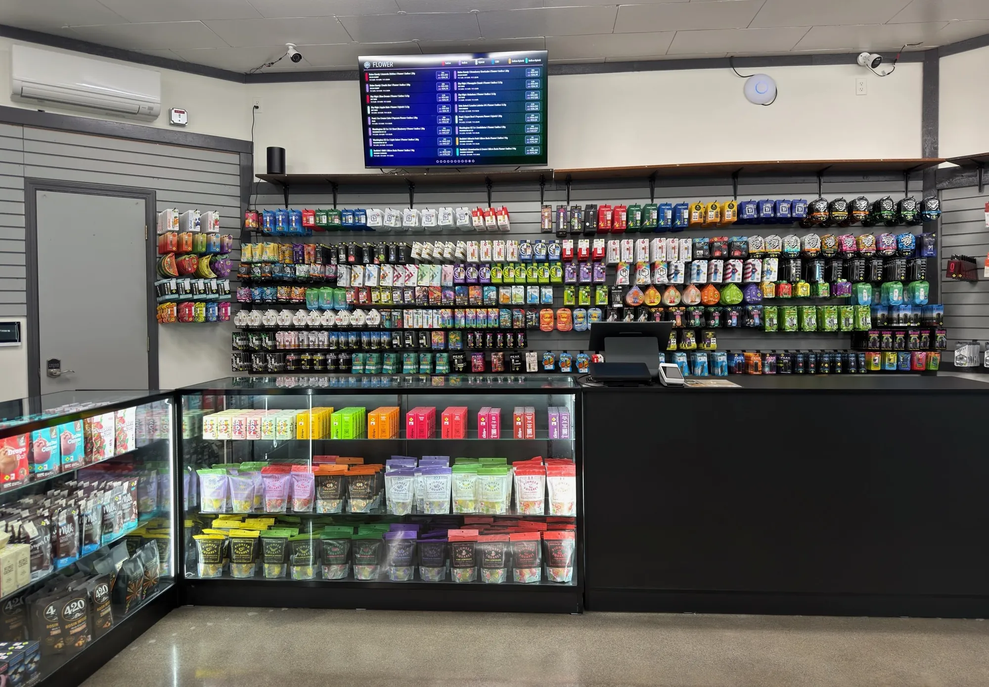 Product wall and display cases beneath the digital menu board at Crystal Leaves